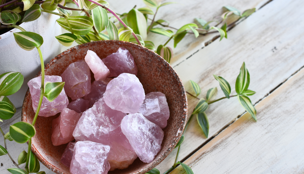 Rose quartz crystal stones in wooden bowl